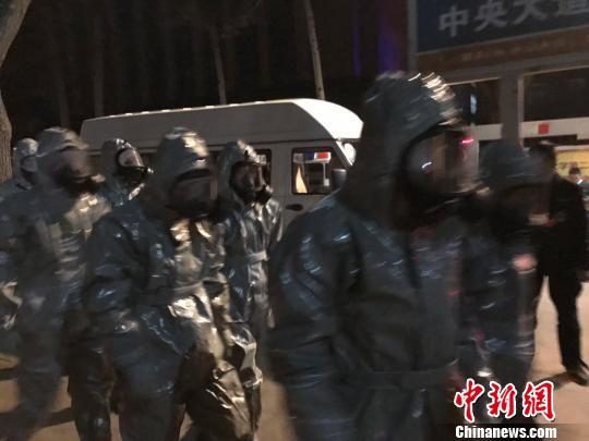 十几名身着防护服的人员头戴面具进入事发地。　胡健 摄